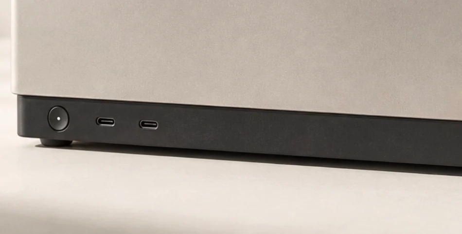 Detail of the same enclosure: circular power button and two USB-C ports along the graphite front base.